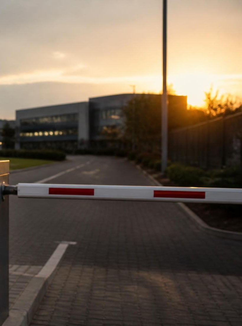 Industrial business park access road with security boom gate at dusk